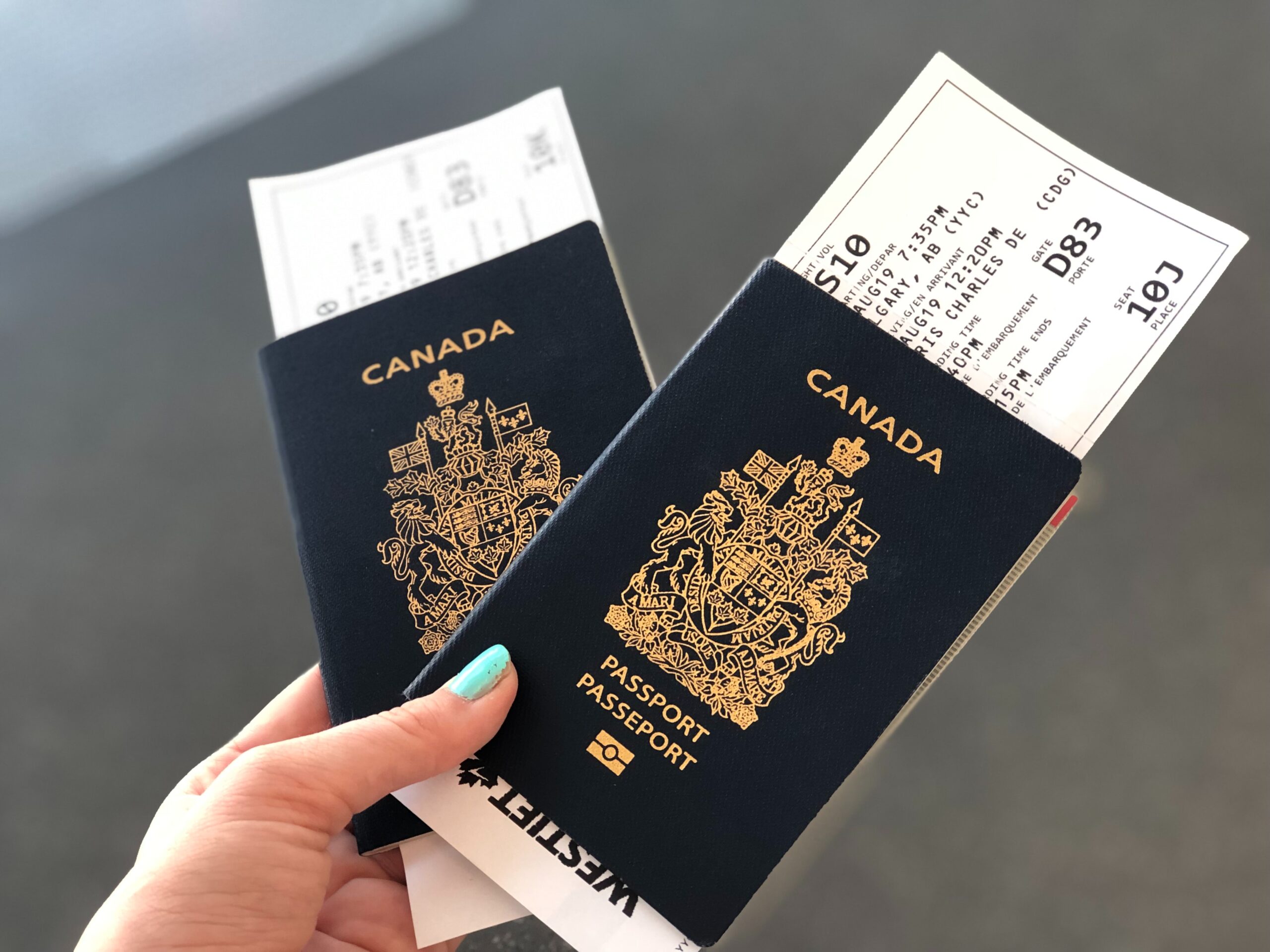 person holding two canadian passports